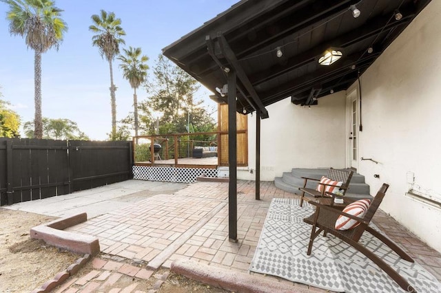 view of patio featuring fence and a wooden deck