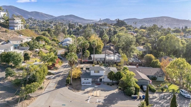 aerial view of property and surrounding area with a mountain backdrop and nearby suburban area