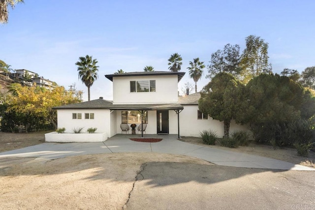 traditional-style home with stucco siding and a porch