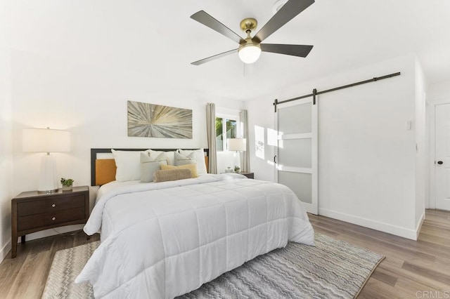 4404 Vista Way, La Mesa, CA 91941 - bedroom with a barn door, wood finished floors, baseboards, and ceiling fan