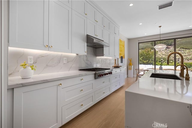 kitchen featuring white cabinets, decorative light fixtures, sink, and stainless steel gas cooktop