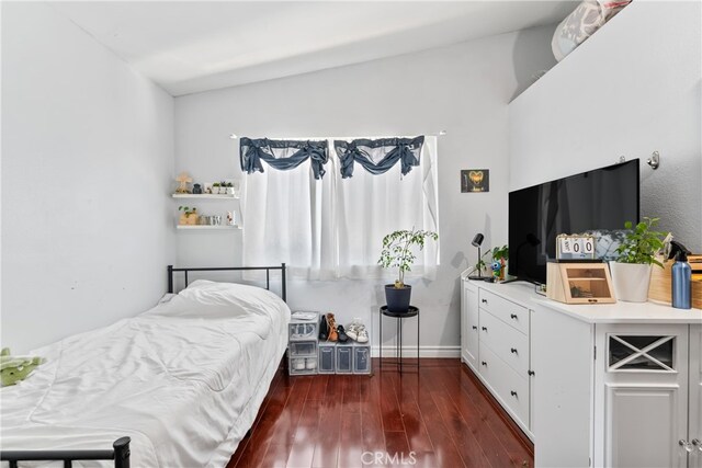 bedroom with dark wood-style flooring and baseboards