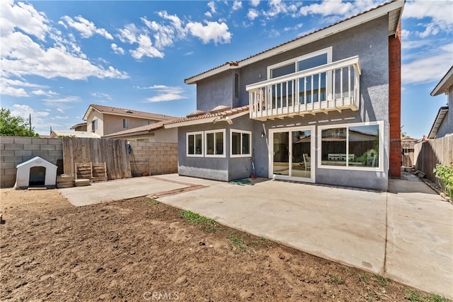 rear view of property featuring a patio area, a fenced backyard, and stucco siding