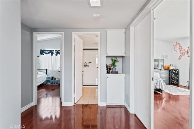 corridor featuring dark wood-style floors and baseboards