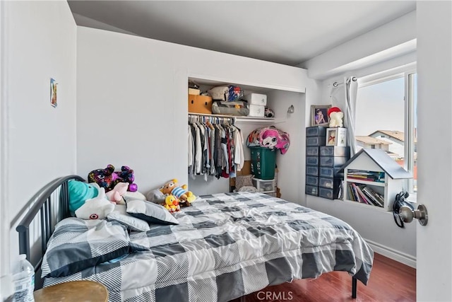 bedroom featuring a closet, wood finished floors, and baseboards