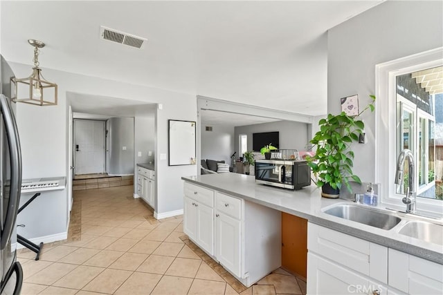 kitchen featuring light countertops, visible vents, appliances with stainless steel finishes, white cabinets, and a sink