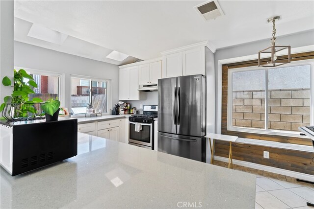 kitchen with under cabinet range hood, stainless steel appliances, visible vents, white cabinets, and light countertops