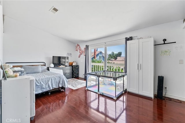 bedroom featuring baseboards, dark wood finished floors, visible vents, and access to exterior