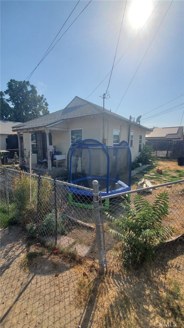 back of property featuring a trampoline and a patio