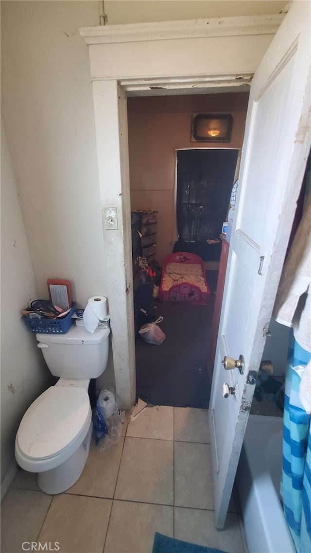 bathroom featuring toilet and tile patterned flooring