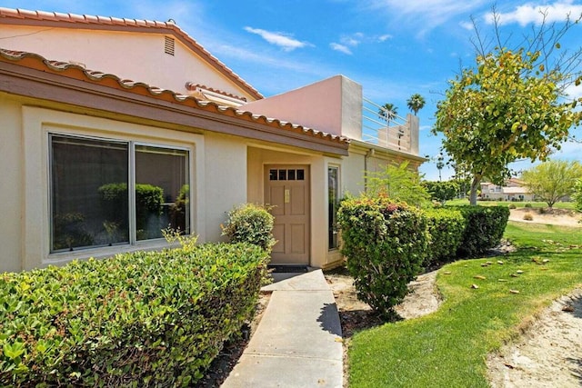 doorway to property with a yard