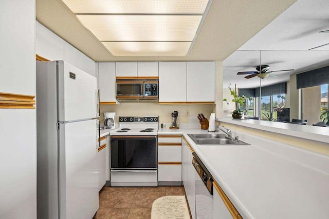 kitchen featuring white appliances, ceiling fan, sink, light tile patterned floors, and white cabinets