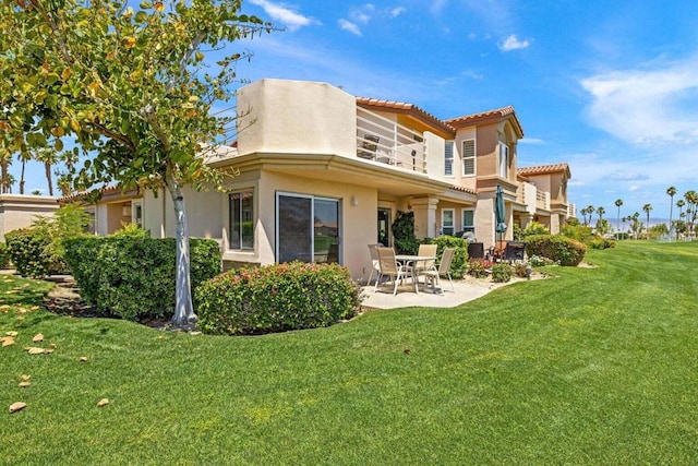 back of property featuring a lawn and a patio area