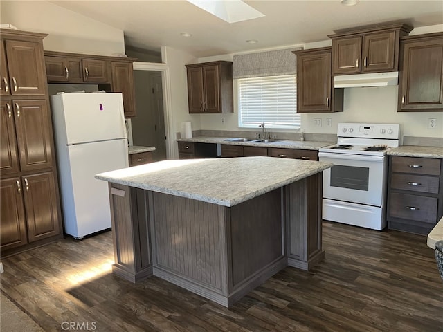 kitchen featuring dark hardwood / wood-style floors, sink, a kitchen island, white appliances, and lofted ceiling with skylight