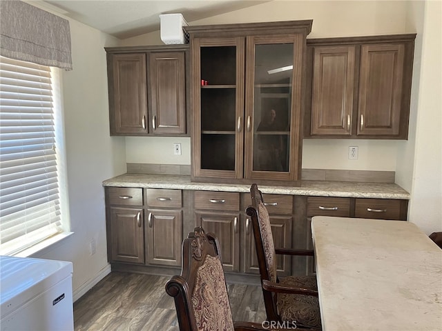 kitchen featuring dark brown cabinetry, dark hardwood / wood-style floors, vaulted ceiling, and a healthy amount of sunlight