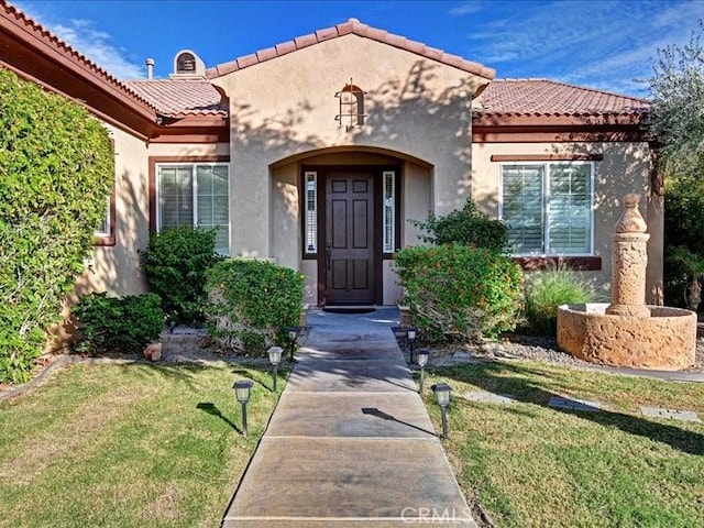 property entrance featuring a lawn