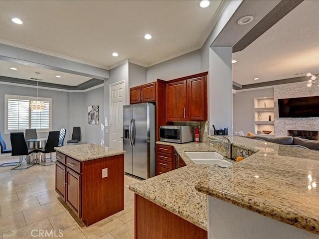 kitchen with sink, light stone counters, kitchen peninsula, pendant lighting, and stainless steel appliances