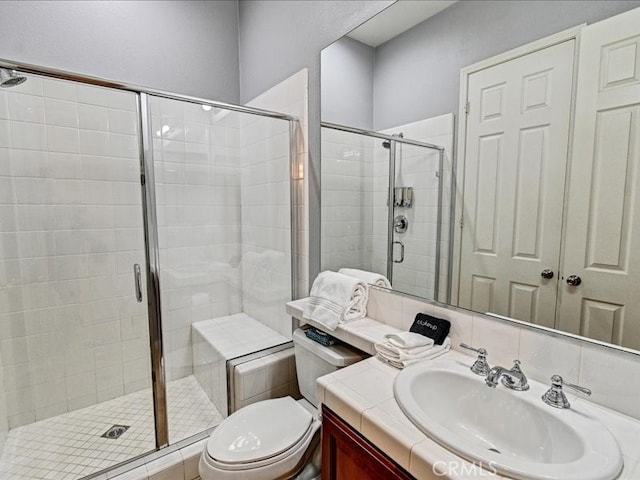 bathroom with toilet, vanity, and a shower with shower door