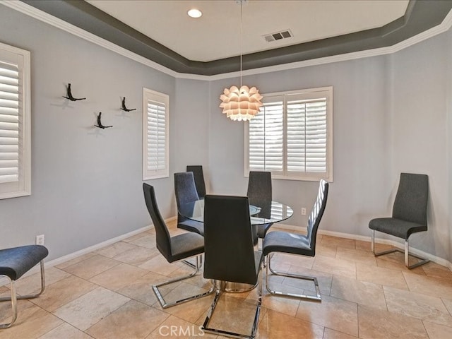 dining room featuring crown molding and a raised ceiling