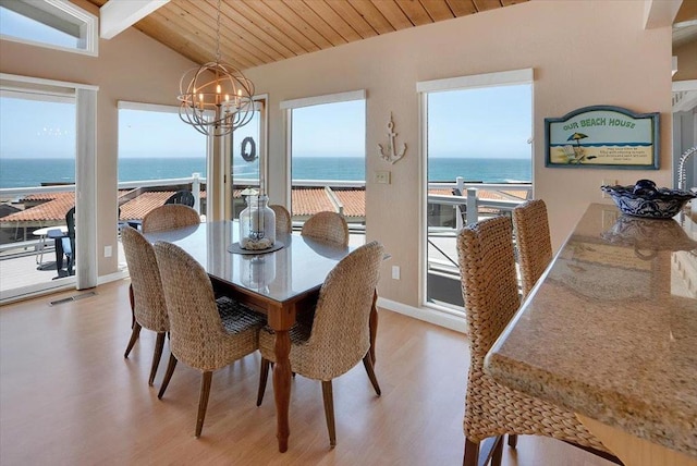 dining space with an inviting chandelier, wooden ceiling, light hardwood / wood-style flooring, lofted ceiling with beams, and a water view