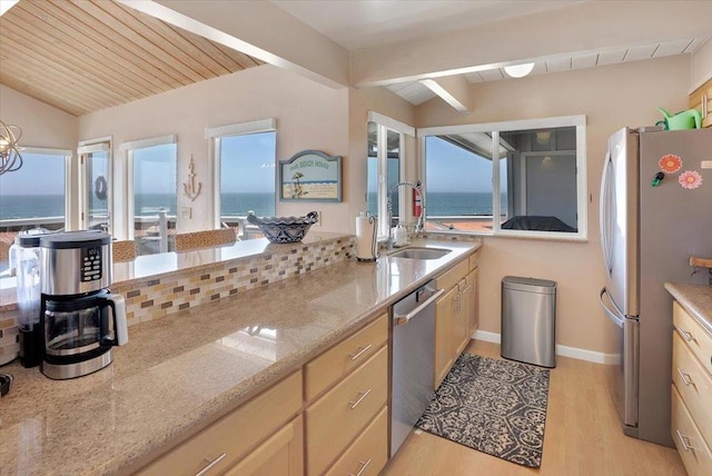 kitchen with wooden ceiling, light wood-type flooring, stainless steel appliances, light stone counters, and a water view