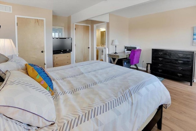 bedroom featuring light hardwood / wood-style floors and ensuite bath