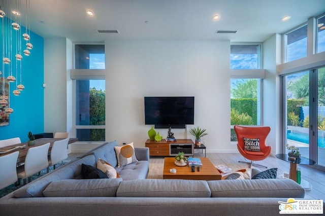 living room with a towering ceiling and hardwood / wood-style flooring