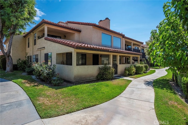 mediterranean / spanish-style home featuring a front yard