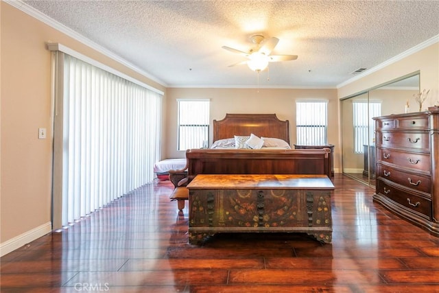 bedroom with multiple windows, crown molding, ceiling fan, and a closet