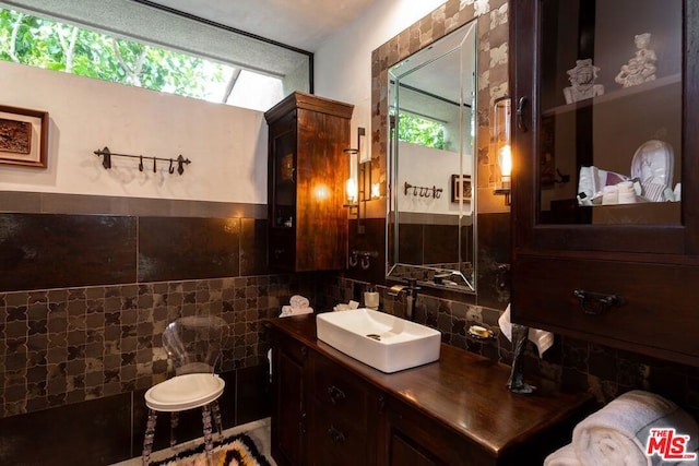 bathroom featuring vanity and tile walls