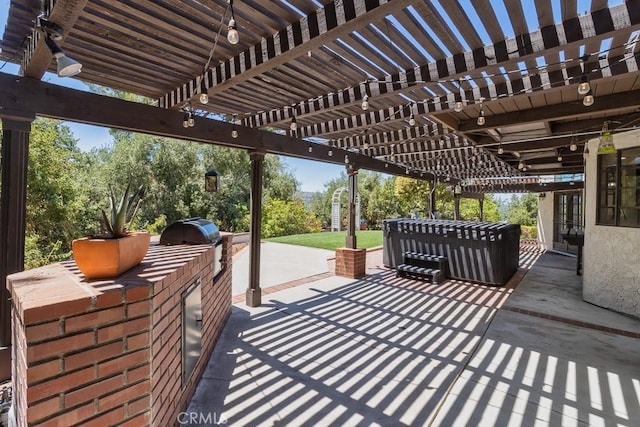 view of patio / terrace with an outdoor kitchen, a grill, a pergola, and a jacuzzi