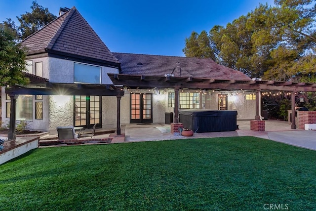 back of house with a yard, a pergola, a patio area, a hot tub, and french doors