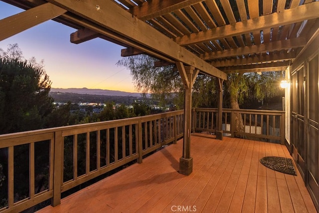 deck at dusk with a pergola and a mountain view