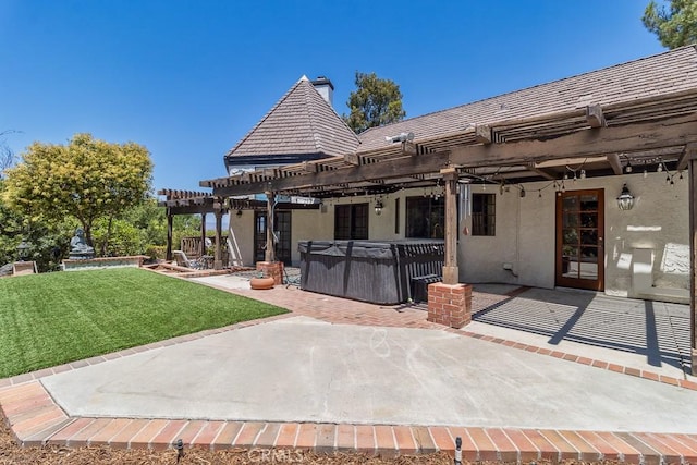 rear view of property with a hot tub, a patio, a lawn, and a pergola