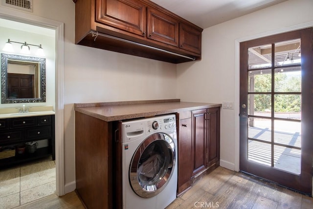 laundry room featuring hardwood / wood-style flooring, cabinets, and washer / clothes dryer