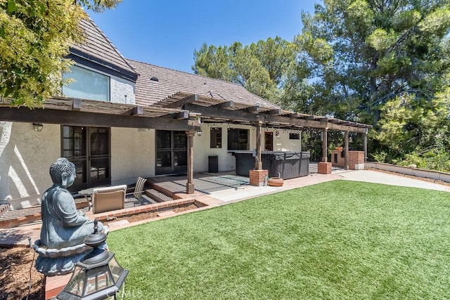 rear view of property featuring a yard, a hot tub, a pergola, and a patio