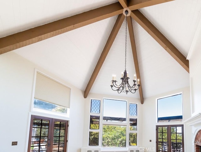 room details with beamed ceiling, a chandelier, and french doors