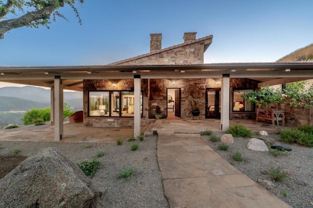 rear view of property featuring a patio area and a mountain view