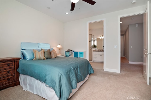 bedroom featuring ensuite bath, light colored carpet, and ceiling fan