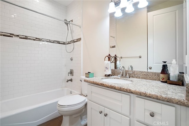 full bathroom with vanity, tiled shower / bath combo, and toilet