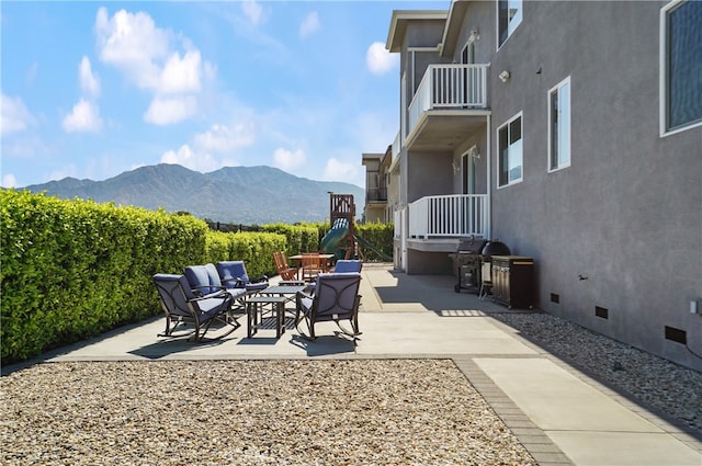 view of patio featuring a balcony and a mountain view