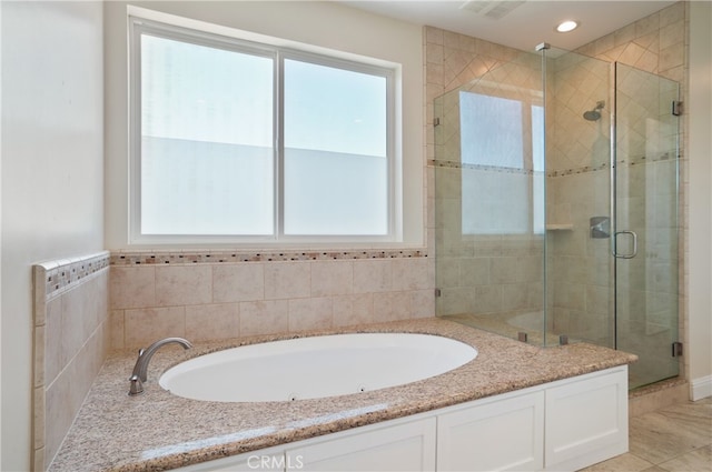 bathroom with a healthy amount of sunlight, tile patterned floors, and separate shower and tub