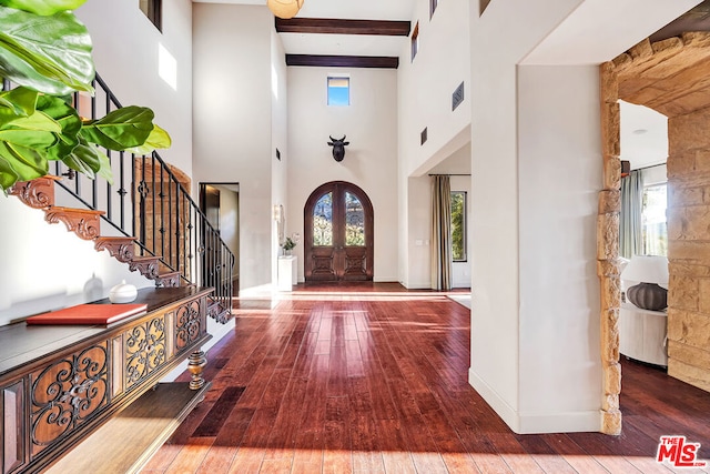 entrance foyer featuring beam ceiling, a towering ceiling, and dark hardwood / wood-style flooring