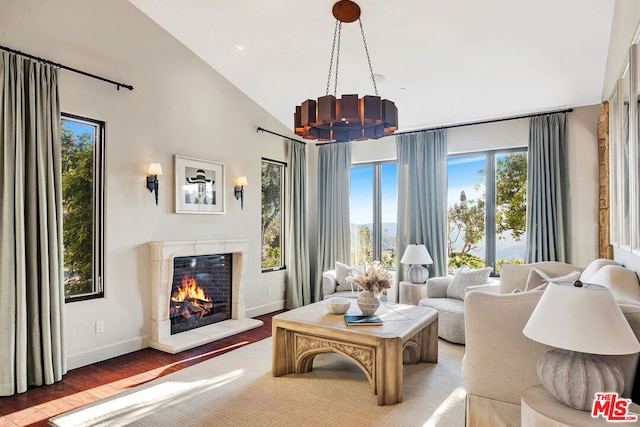 living room featuring an inviting chandelier, high vaulted ceiling, and hardwood / wood-style flooring