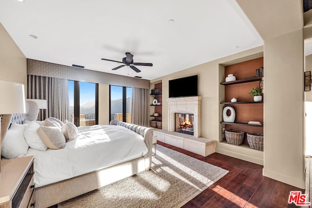 bedroom with access to exterior, ceiling fan, a fireplace, and dark wood-type flooring