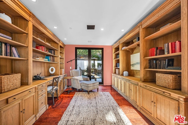 interior space featuring built in desk, dark wood-type flooring, and french doors