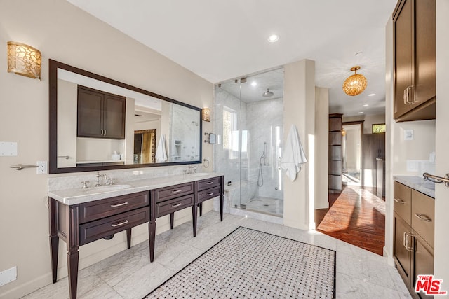 bathroom featuring hardwood / wood-style floors, a shower with door, and vanity