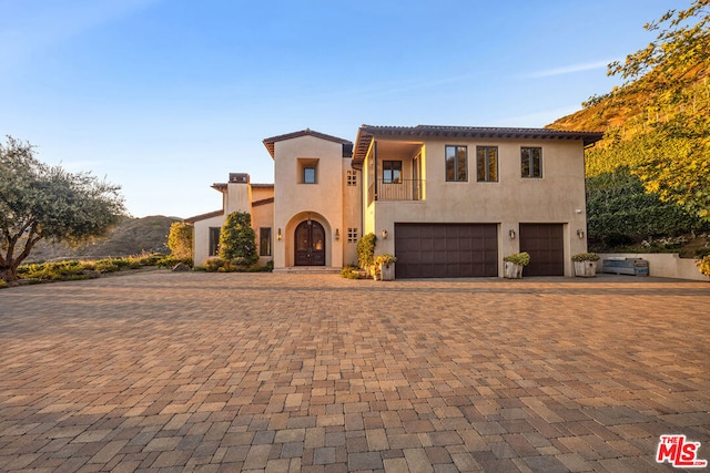 mediterranean / spanish-style home featuring a balcony and a garage