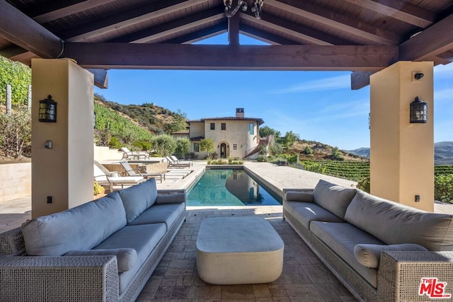 view of swimming pool featuring an outdoor hangout area, a gazebo, a mountain view, and a patio area