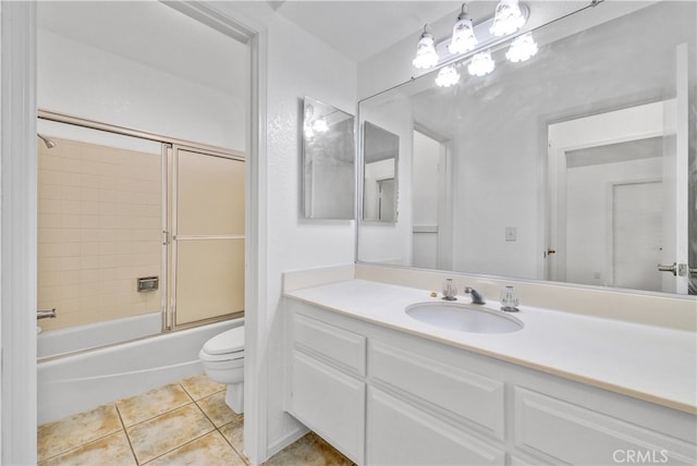 full bathroom with combined bath / shower with glass door, vanity, toilet, and tile patterned floors